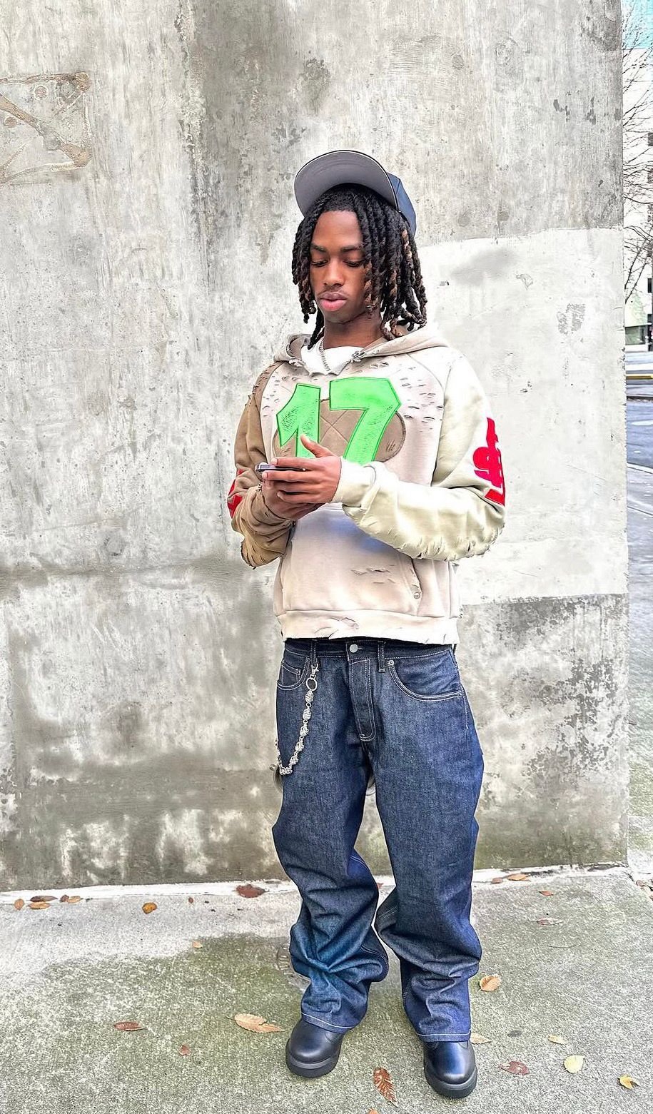 Distressed 17 hoodie and raw denim against concrete