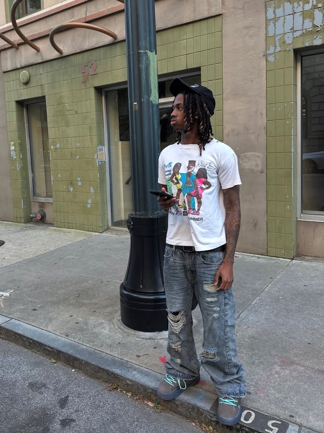 Vintage graphic tee and ripped denim, curbside