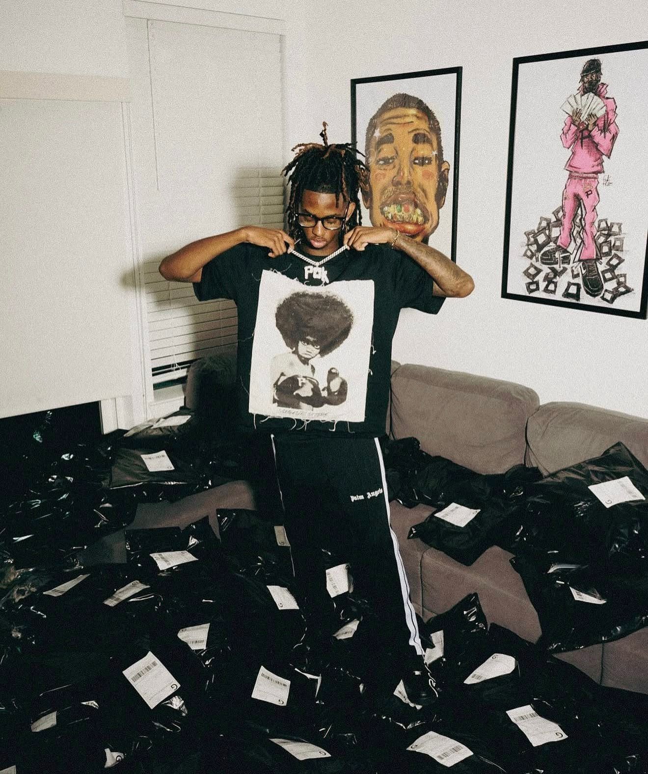Holding a Pieces of Knowledge graphic tee at home